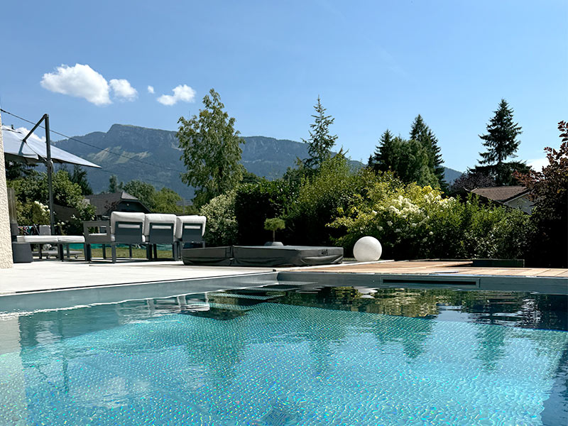 piscine_inox_garantie_a_vie Piscine inox devant une terrasse dans un jardin végétalisé